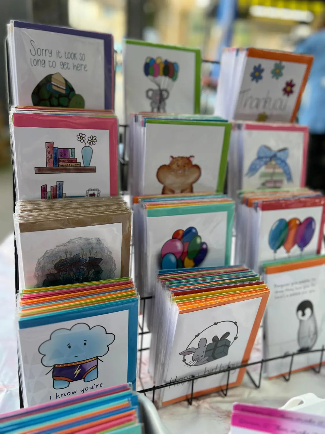A tiered stand of 12 different greetings cards. The background is blurred out. 