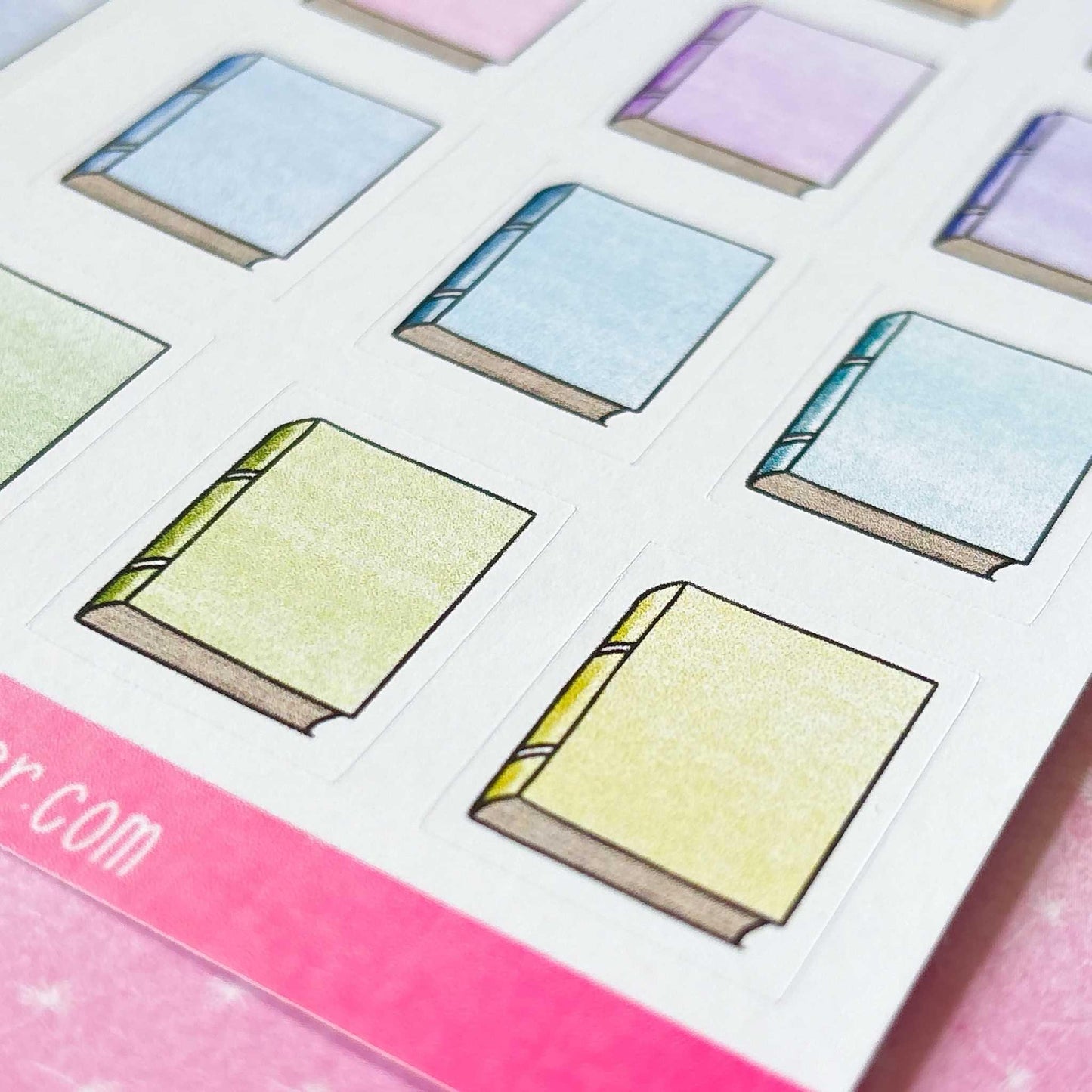 Introducing the Bookworm Sticker Sheet: a collection of book icon stickers in assorted pastel colors, ideal for planner decoration or celebrating bookworm milestones, neatly arranged in a grid on a single sheet.