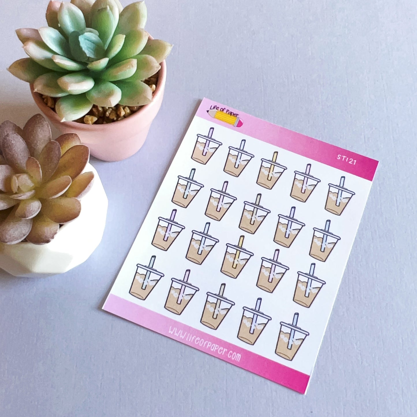 A sheet of Iced Coffee Planner Stickers featuring cartoon bubble tea cups with blue straws on a light purple background. Two small succulent plants in pots are placed on the left side of the sheet, evoking summer cold drinks. The sheet has a pink border at the top and bottom.