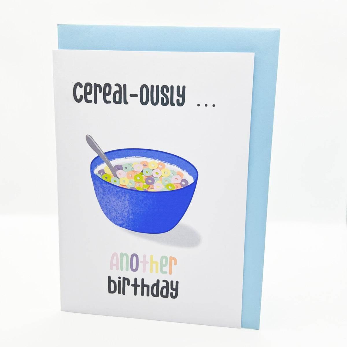 The "Cereal-ously Another Birthday" card is a colorful birthday greeting featuring a blue bowl of vibrant cereal with a spoon on the front. Above the bowl, it reads "Cereal-ously..." and below, in playful, multicolored text, it continues with "another birthday." Perfect for wishing your friend a Happy Birthday!