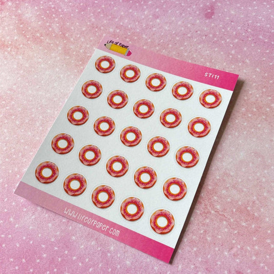 A sheet of Doughnut Stickers featuring circular stickers with red and orange doughnut designs on a pink dotted-textured background. Perfect for adding flair to your journal spread, the top of the sheet reads "Life of Paper.