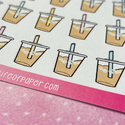 These Iced Coffee Stickers featuring colorful summer cold drinks with straws are displayed on a pink and white sheet, and the bottom partially reveals the website URL "onceuponalifewithpaper.com".