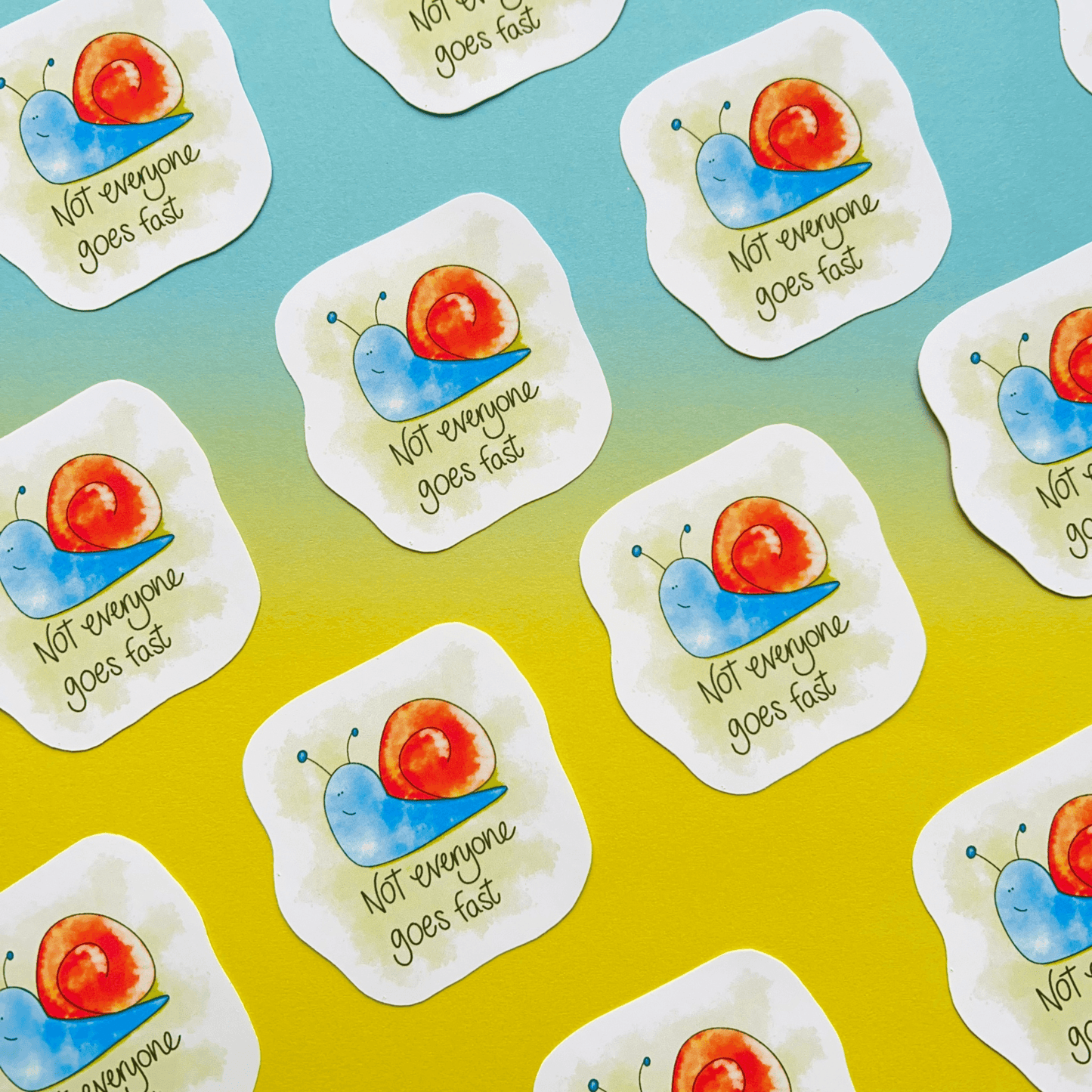 The Speedy Snail - Animal Vinyl Sticker displays vivid snails accompanied by the phrase "Not everyone goes fast," set diagonally on a gradient blue and yellow backdrop. These durable, water-resistant vinyl stickers are ideal for creating vibrant and lasting decals.