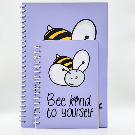 Two A6 "Be Kind To Yourself" notebooks, high-quality with purple spiral bindings, featuring a cartoon bee and the text on the covers.