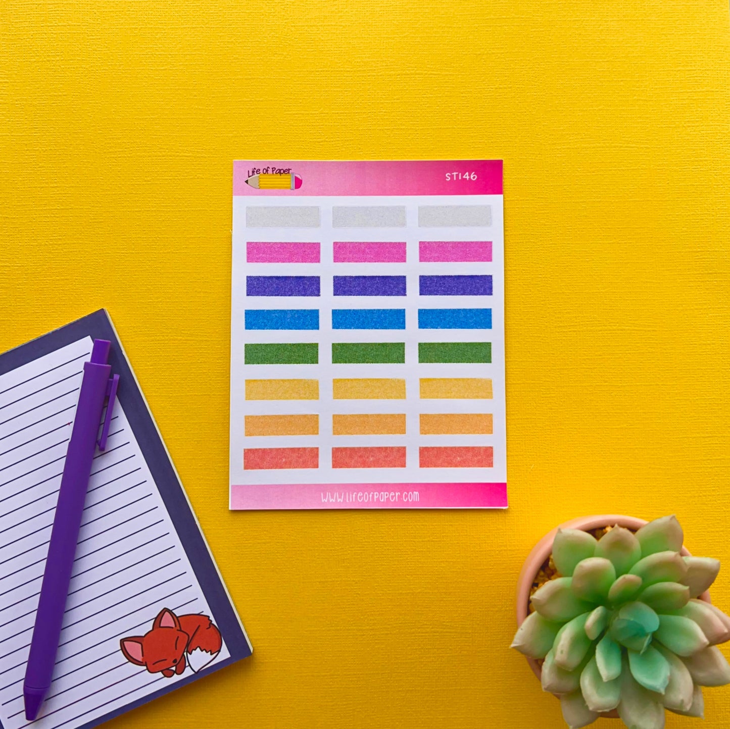 A sheet of Textured Box Planner Stickers with 30 labels arranged in a 5x6 grid is placed on a bright yellow background. To the left is a lined notepad with a purple pen, and a small sticker of a fox in the bottom corner. A succulent plant is on the right, perfect for organising your planner.