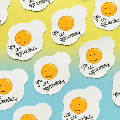 The Extraordinary Silly Pun Quote Vinyl Sticker, featuring waterproof sunny-side-up eggs with smiley faces and the text "You are eggtraordinary" on a blue and yellow gradient background, makes the perfect gift for a friend.