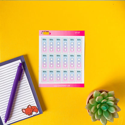 A yellow surface holds a sheet with a grid titled "Bills" adorned with Bill Tickbox Planner Stickers and unchecked boxes, a notepad with a fox design and a purple pen, and a green succulent plant in a round pot.