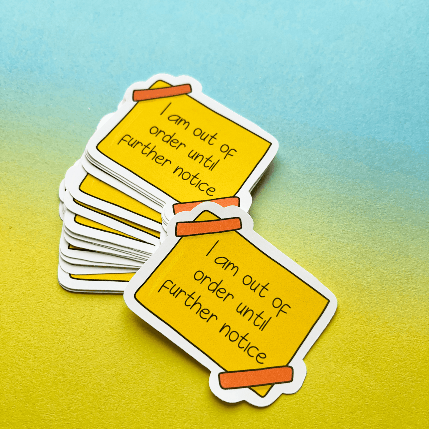 Stack of Out of Order Stickers featuring the text "I am out of order until further notice" on a gradient blue to bright yellow warning background, made from strong matte vinyl that is water-resistant.