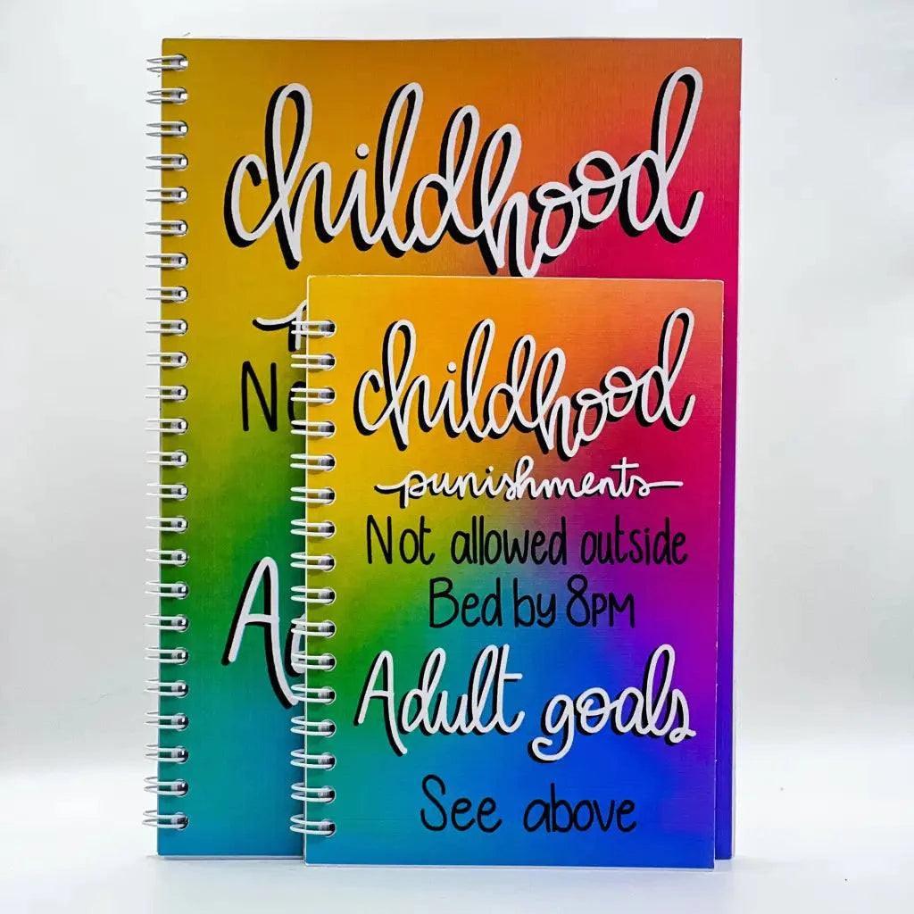 Two spiral-bound notebooks with vibrant gradient covers. The larger A5 notebook, titled "Adulting Goals A5 Notebook," features the word "childhood" written in cursive. The smaller notebook, with premium 120gsm paper, displays the text: "childhood punishments: Not allowed outside, Bed by 8pm. Adulting goals: See above.