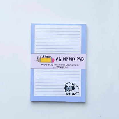 A blue A6 memo pad with lined pages and a sheep illustration on the bottom right corner of the cover. The title "Animal Collection Memo Pads" is written on the cover band along with "Life of Paper" and the URL "www.lifeofpaper.com". Perfect for gift sets, this cute addition belongs to our range of animal memo pads.