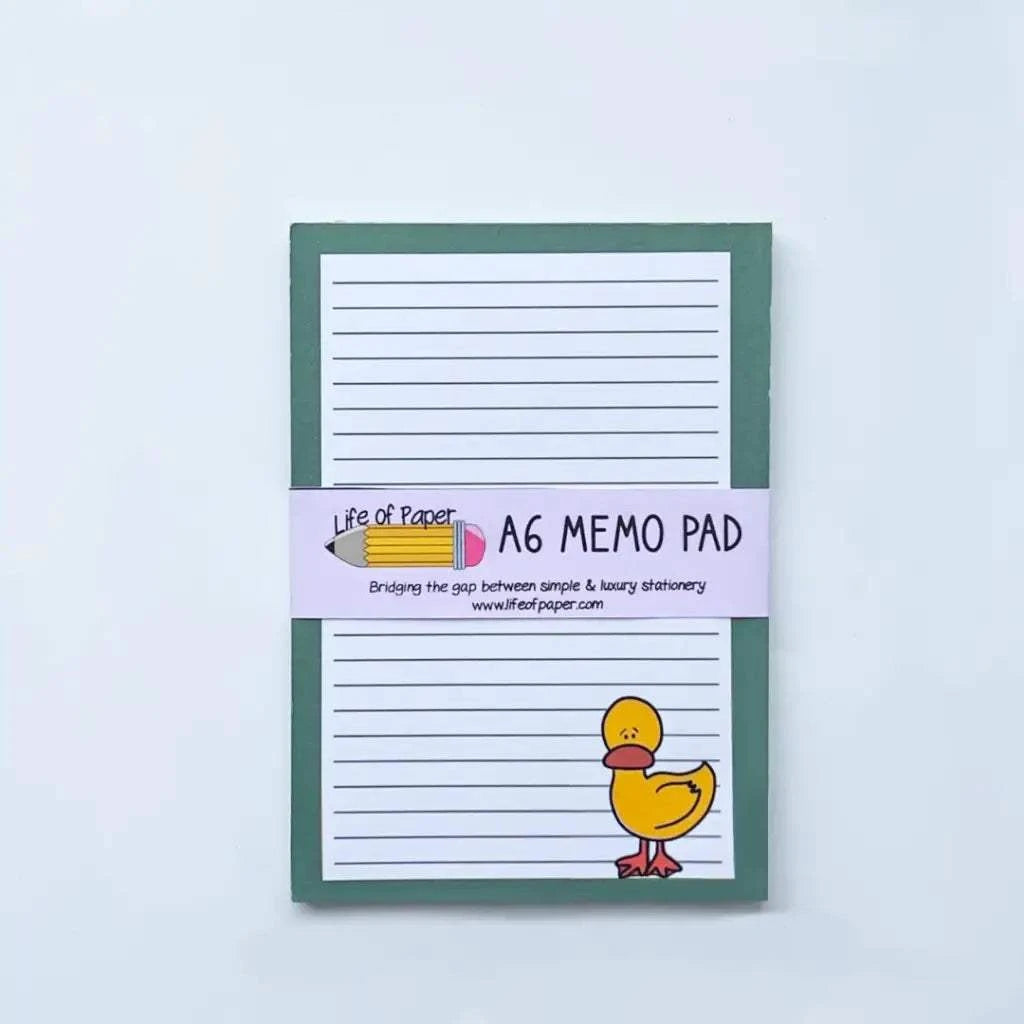 A green-bound A6 memo pad with lined paper, featuring an illustration of a yellow duck on the bottom right corner. The label around it reads "Animal Collection Memo Pads" and features a pencil graphic. Perfect for those who cherish animal memo pads. Tagline: "Bridging the gap between simple & luxury stationery.