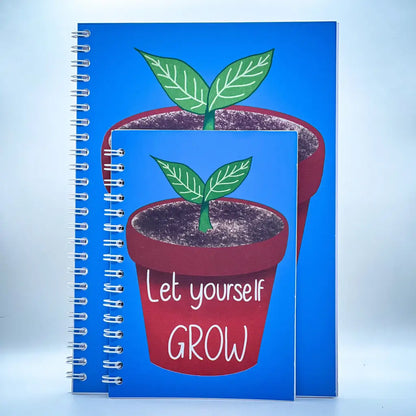 Two spiral-bound notebooks with blue covers, each featuring an illustration of a small potted plant with green leaves. The larger Let Yourself Grow Notebook has the phrase "Let yourself GROW" written below the pot, offering a self-esteem boosting message with its positive quote.