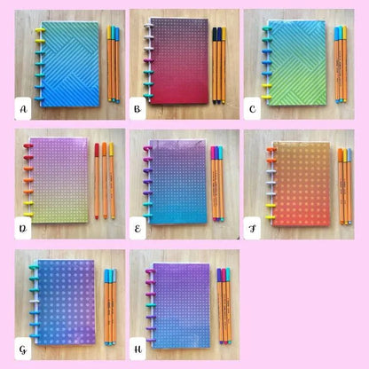A collage of seven colorful refillable Tiny Notes Notebooks, each with a matching set of fountain pen friendly pens. The notebooks vary in gradient designs and colors, labeled A to H. The background is pink, and the MAMBI Happy Planner compatible notebooks are displayed against a light wooden surface.
